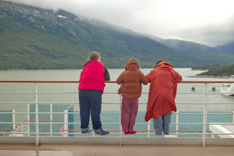 three kids on cruise deck looking at mountains