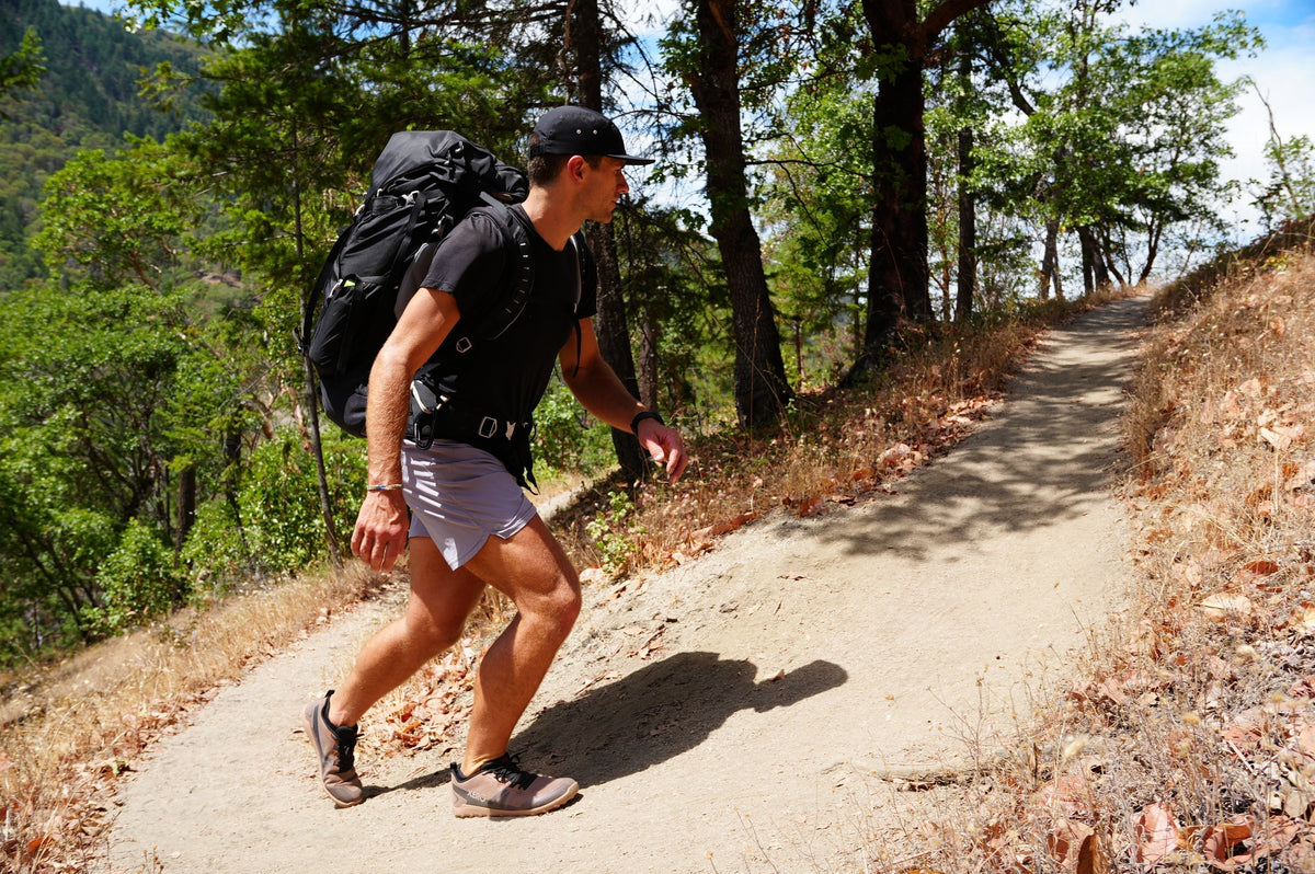 man hiking in xero shoes on dirt path