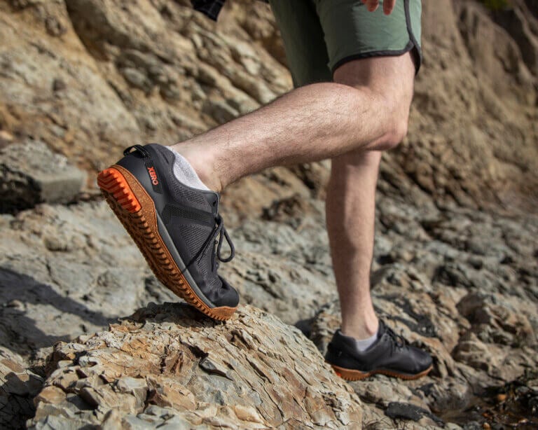 A man hiking over rocky terrain in his Rideway Mesh Low shoes