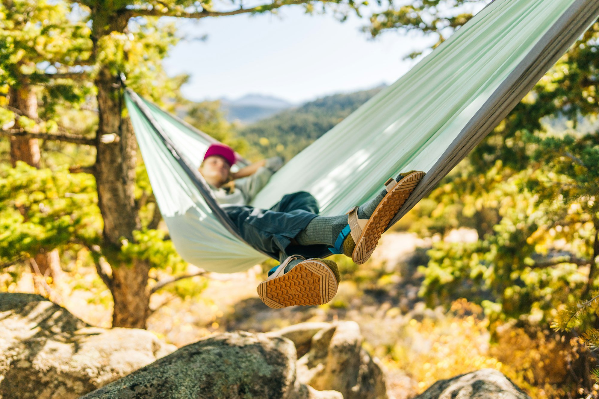 A woman resting in the hammock wearing his D-Trail sandals.