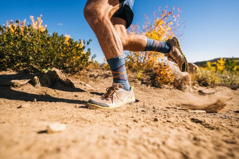 A man running down a dry dirt trail with his Scrambler Low EV shoes.