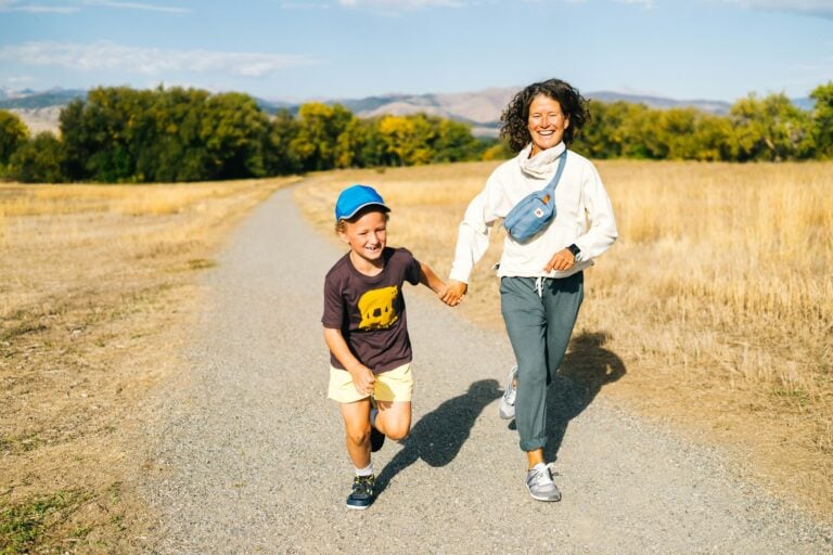 A woman and her son walking down a gravel path. The mother is wearing her Wynn shoes.