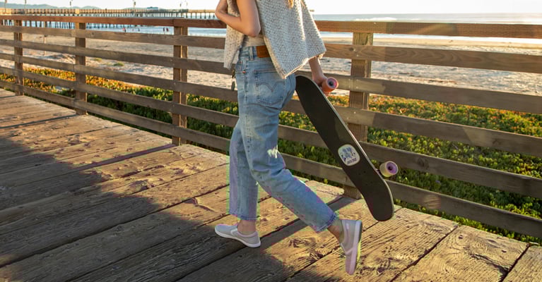 woman wearing the lunar rock dillon canvas slip-ons walking on boardwalk by the beach