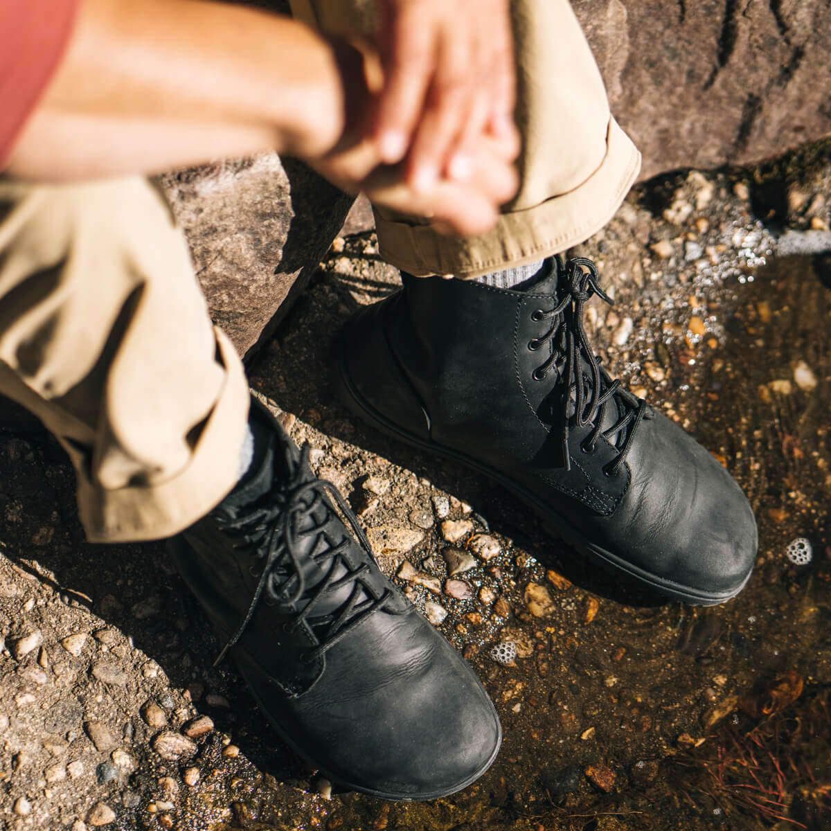 Denver II men’s black leather ankle boot, with black sole and lace-up front, top view while seated outdoors